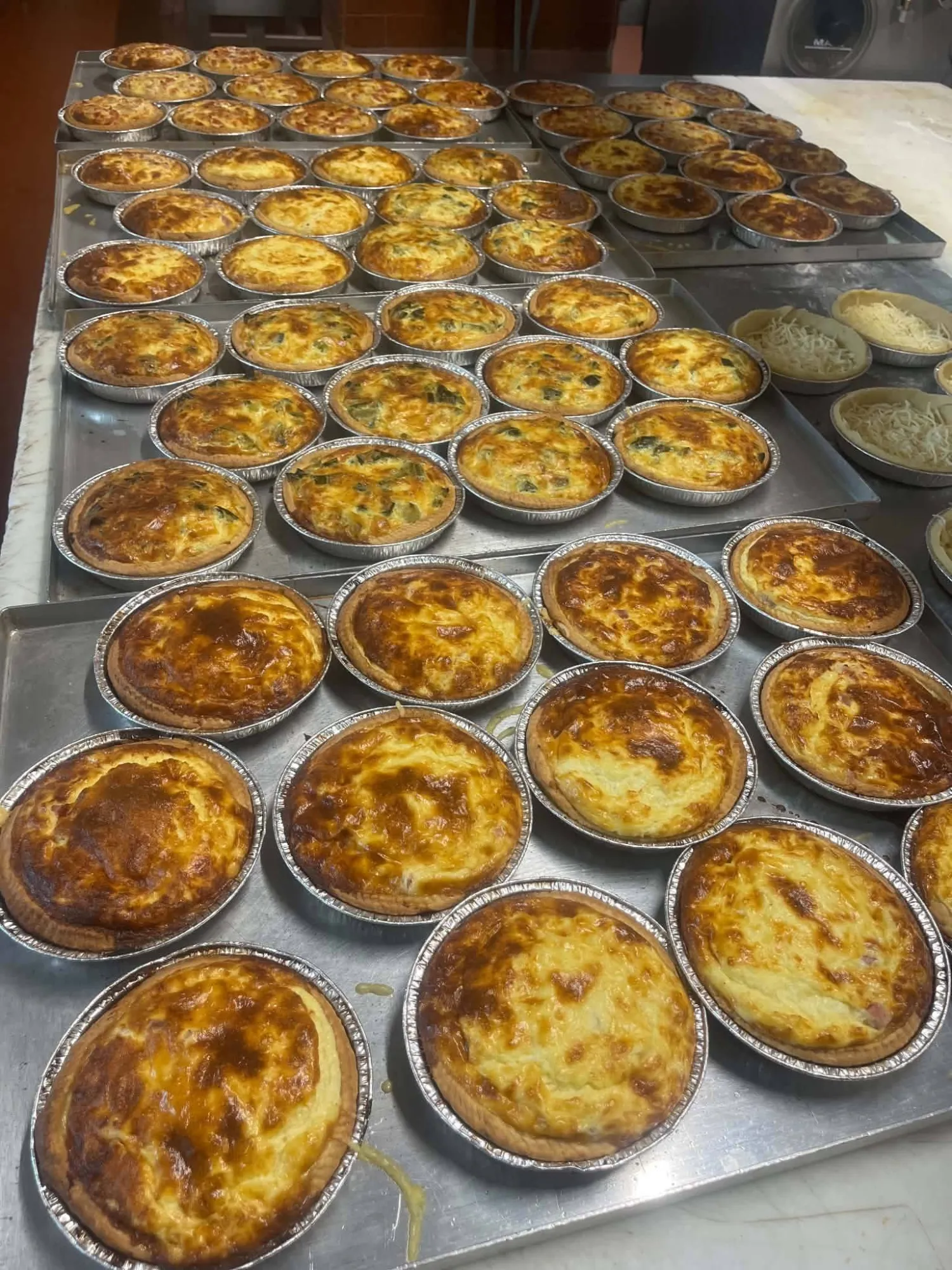 Plaques de tartes salées dorées tout juste sorties du four, dans l'atelier